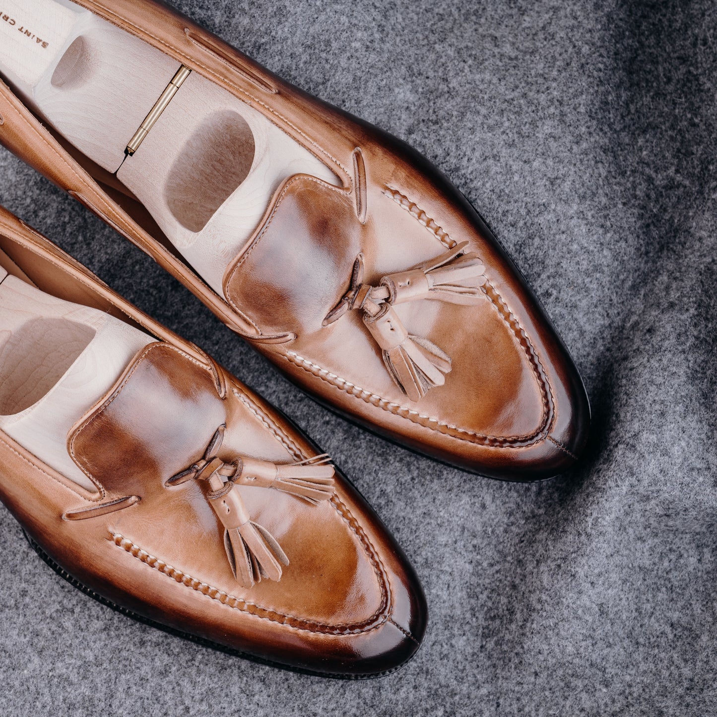 Loafer with hand stitched apron, tassels and plain band, patinized