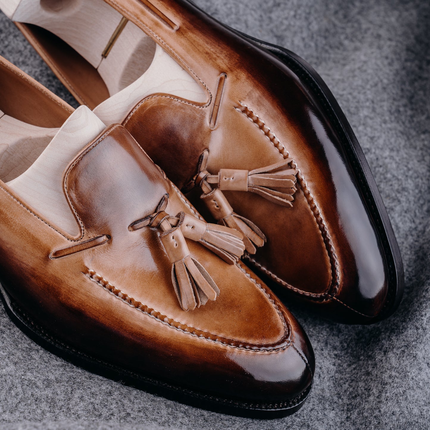 Loafer with hand stitched apron, tassels and plain band, patinized