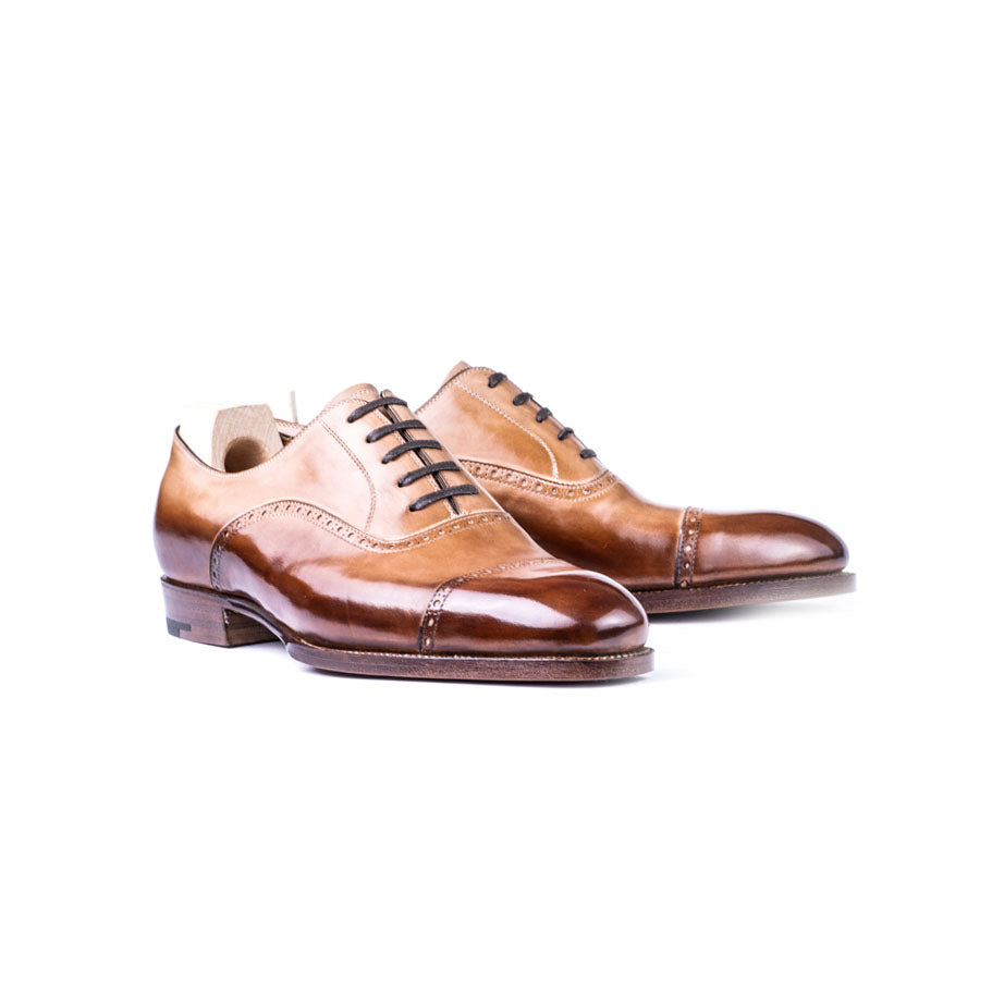 Oxford with small brogueing on the straight toe cap and counter
